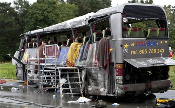 The wreckage of a bus that carried Polish tourists stands on the highway after it crashed in Schoenefeld east of Berlin, Germany, on Sunday. German police say at least 12 people were killed and dozens injured in the accident.